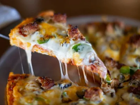 Specialty pizza with melted cheese pull at Spiro's Pizza & Pasta in Shoreline WA
